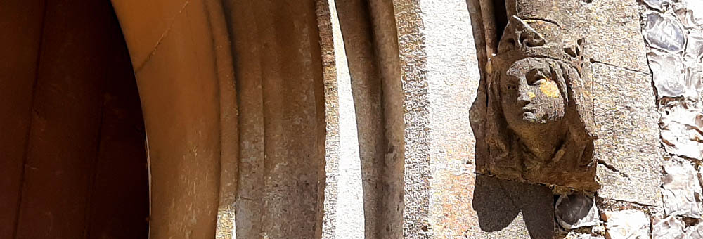 Newton Toney Wiltshire village image showing a stone head on the church